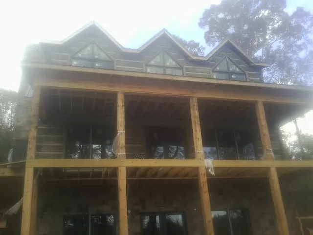 Dormers and porch framing on a large log home under construction — Roof Coating work by our crew in San Gabriel