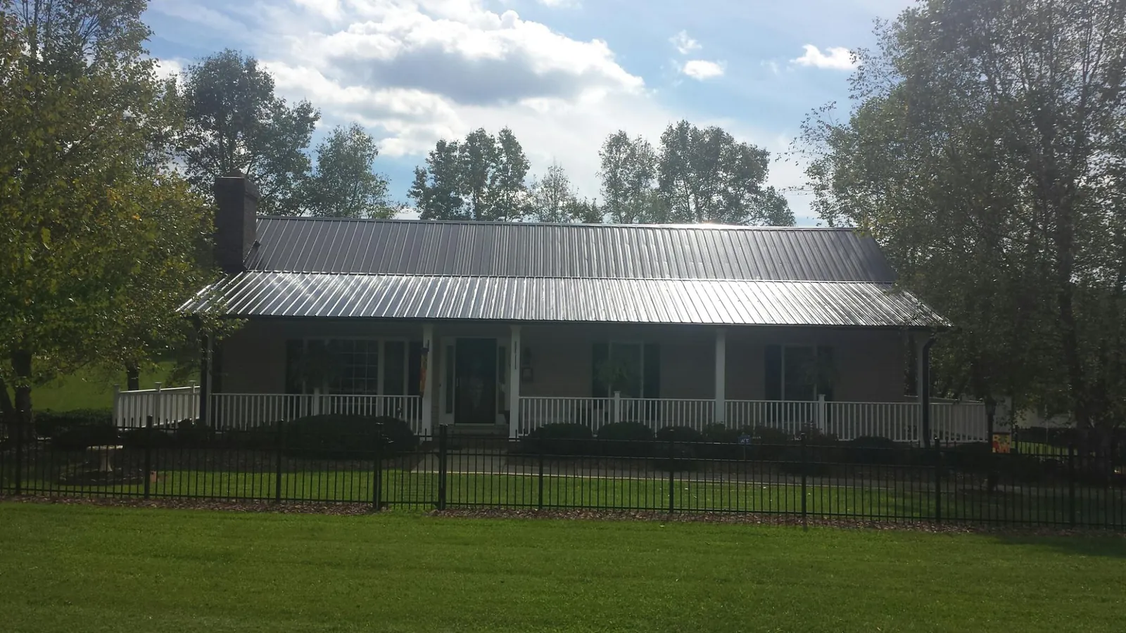 Gray metal roof on a brick ranch with a full width front porch — Gutter Guard Installation work by our crew in San Gabriel